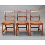 A set of 3 18th Century elm and fruitwood country ladderback dining chairs with solid seats One