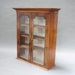 A Victorian Continental mahogany cabinet with moulded cornice, fitted shelves enclosed by