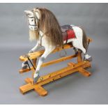 A dappled grey rocking horse, raised on a pine stand 106cm h x 117cm This lot is being sold on
