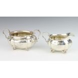 A Sterling silver sugar bowl and cream jug on scroll feet 215 grams