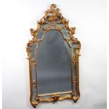 An Italian style arched plate mirror contained in a decorative carved hardwood gilt frame 132cm h