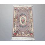 A beige ground and floral patterned Chinese rug with floral decoration 155cm x 89cm
