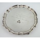 A silver salver with Chippendale rim and presentation inscription, on scroll feet, Sheffield 1977,