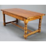 A rectangular oak refectory dining table raised on turned and block supports with H framed stretcher
