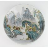 A Chinese shallow dish decorated with figures in boats with extensive mountain range and