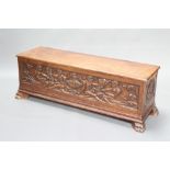 An Italian carved oak coffer of panelled construction with hinged lid, carved mythical scenes raised