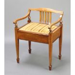An Edwardian inlaid mahogany stick and rail back box seat piano stool, raised on square tapered