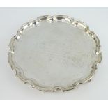 A silver salver with Chippendale rim and engraved inscription, on scroll feet, Birmingham 1973,