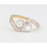 An 18ct yellow gold Edwardian style 2 stone diamond cross-over ring, the 2 brilliant cut diamonds