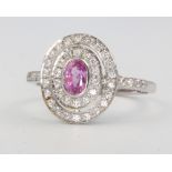 A platinum oval pink sapphire and diamond cluster ring, the centre stone approx. 0.5ct, diamonds 0.