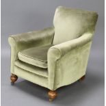 A Howard style armchair upholstered in green Dralon, raised on bun feet