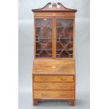 An Edwardian Georgian style inlaid mahogany bureau bookcase with broken pediment to the top,