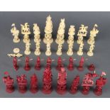 A carved Cantonese and stained ivory chess set, the King 13cm, bases with carved concentric balls