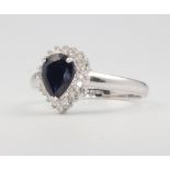 An 18ct white gold pear cut sapphire and diamond cluster ring, centre stone 1.37ct, surrounded by