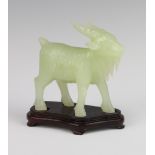 A Chinese carved hardstone figure of a goat on a carved hardwood stand 10cm