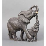 An African carved hardstone figure of a standing elephant and calf 21cm h x 25cm w x 9cm d The tusks