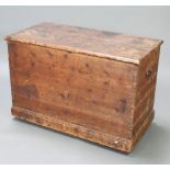 A 19th Century pine trunk with hinged lid and iron drop handles, raised on a platform base 64cm h