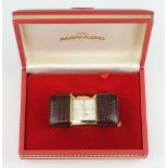 A Movado gilt metal leather mounted travelling bedroom timepiece in original box