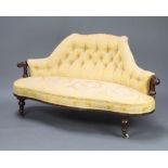 A Victorian metal and mahogany show frame sofa upholstered in yellow buttoned material raised on