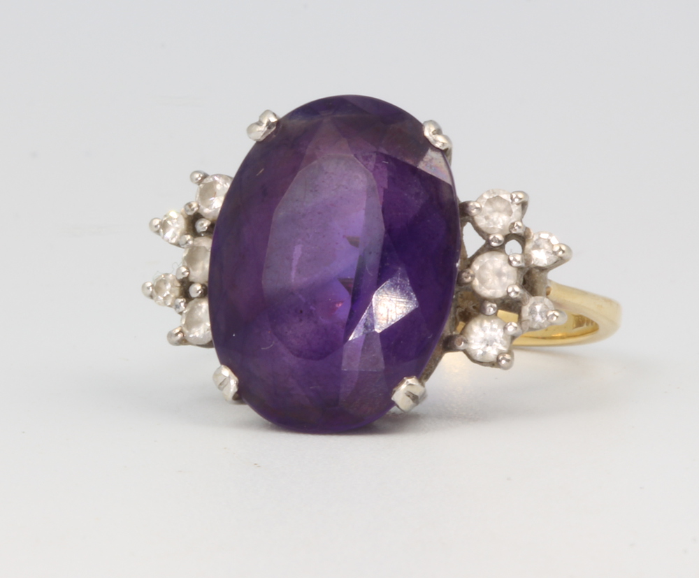 An 18ct yellow gold oval amethyst and diamond dress ring, 6.3 grams, size M