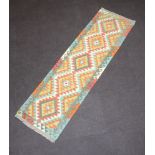 A green, white and brown ground Chobi Kilim runner with 5 diamonds to the centre 204cm x 57cm