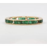 An 18ct yellow gold emerald eternity ring, 2.8 grams, size P 7 stones are missing