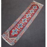 A red and blue ground Caucasian style runner with 6 cross shaped medallions to the centre 301cm x