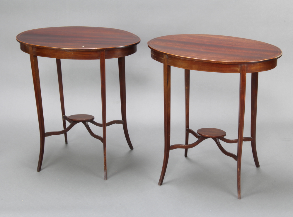 A pair of Edwardian oval inlaid mahogany 2 tier occasional tables, raised on outswept supports