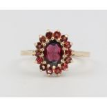 A 9ct yellow gold oval garnet cluster ring, size N, 2.6 grams