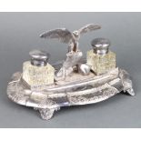 An Edwardian silver plated ink stand with an eagle sitting on a rock flanked by inkwells, raised
