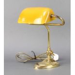 A brass bank table lamp with amber coloured glass shade 31cm h