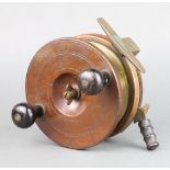 An Edwardian large wooden and brass star back game fishing reel with drum and handbrake lever 15cm