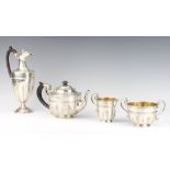 A 3 piece silver tea set with strap work decoration, fancy scroll handles and hardwood mounts,