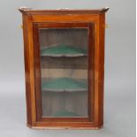 A 19th Century mahogany hanging corner cabinet with moulded cornice fitted shelves enclosed by
