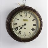 An Edwardian timepiece with painted dial and Roman numerals contained in a carved oak case with rope