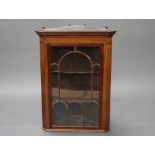 A 19th Century mahogany hanging corner cabinet with moulded and dentil cornice, fitted adjustable