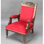 An Edwardian carved oak show frame open armchair, the seat and back upholstered in red material,