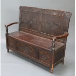 A Victorian carved oak settle with hinged lid 99cm h x 124cm w x 45cm d