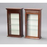 A pair of 19th Century mahogany display cabinets with moulded cornice, fitted shelves enclosed by