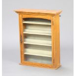 An Art Nouveau light oak hanging cabinet with moulded cornice, interior fitted adjustable shelves