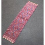 A red and blue ground Meshwani runner with 4 diamonds to the centre with a multi-row border 246cm