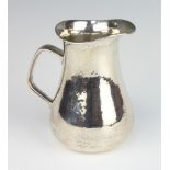 A silver hammered pattern jug with stylish handle, London 1985, 15cm, 465 grams