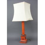 A red lacquered table lamp in the form of a column raised on a square base 54cm x 15cm