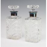A pair of square spirit decanters and stoppers with silver collars 21cm