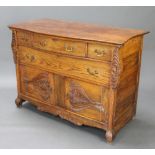A 19th Century Continental carved oak bow front commode fitted 1 long and 2 short drawers with