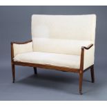 An Edwardian Art Nouveau inlaid mahogany 2 seat sofa upholstered in yellow material raised on square