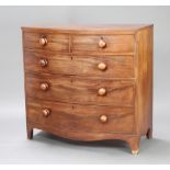 A Georgian mahogany bow front chest of 2 short and 3 long drawers with tore handles, raised on
