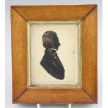 A 19th Century silhouette miniature portrait of a gentleman with gilt highlights in maple walnut
