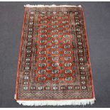 A brown and white ground Bokhara rug with 36 octagons to the centre 200cm x 120cm Some fringing is