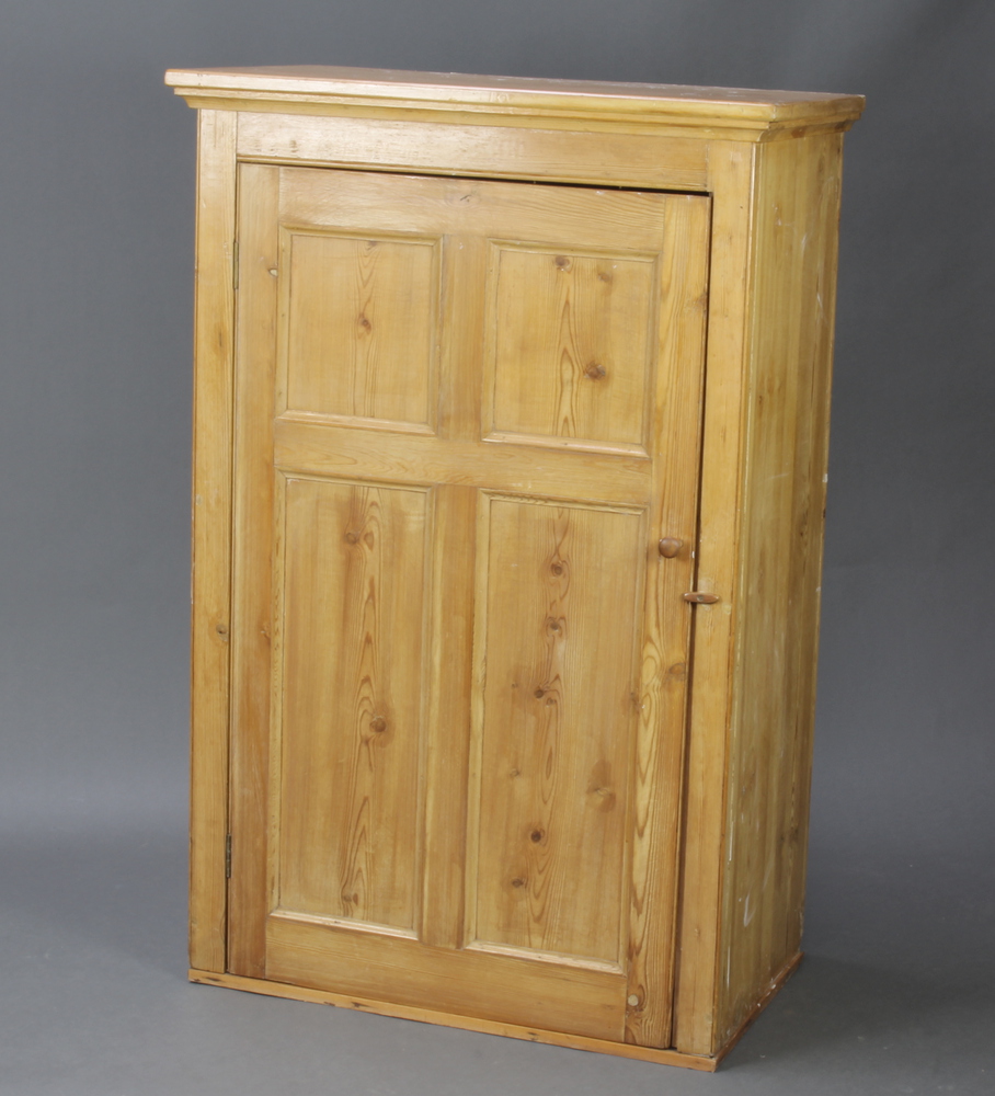 A Victorian pine cabinet with moulded cornice, the interior fitted shelves enclosed by a panelled